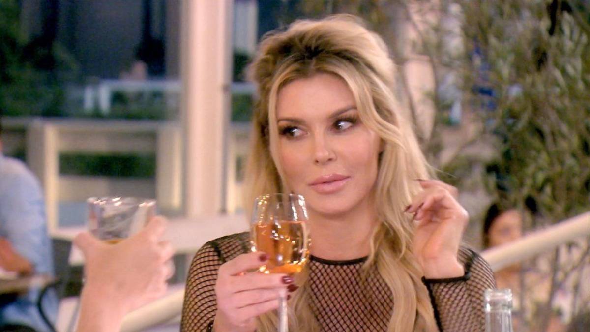 Brnadi Glanville holds a wine glass while filming RHOBH.