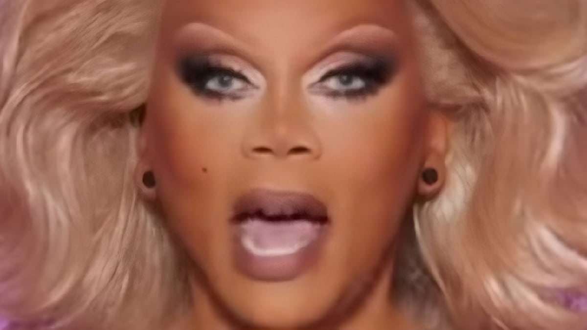 A close up screenshot of RuPaul in a blonde wig with silver eye shadow and burgundy lipstick talking about the maxi challenge