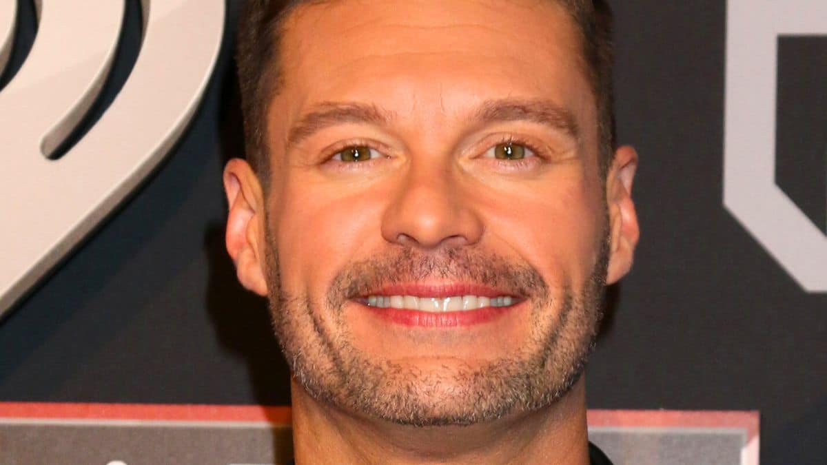 ryan seacrest poses on the red carpet at the forum in L.A.