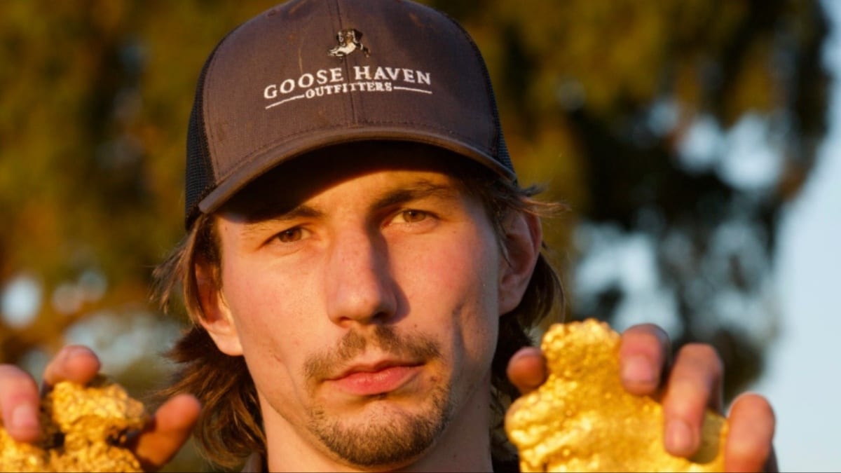 Parker Schnabel posing with gold nuggets