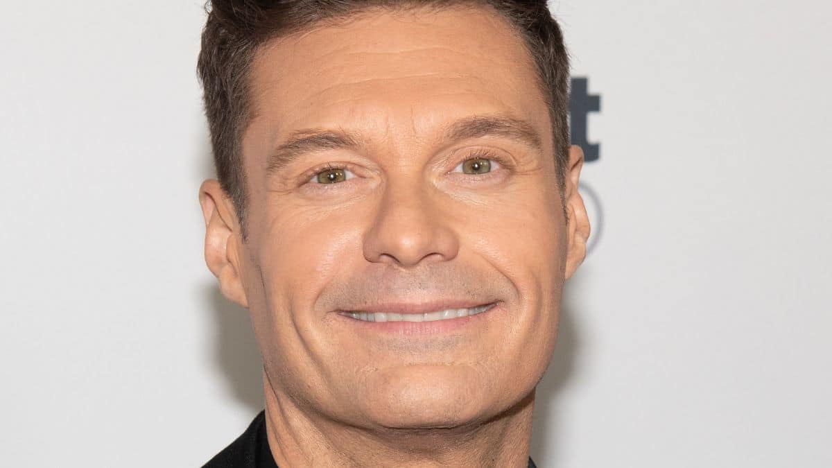 ryan seacrest poses for photographers on the red carpet